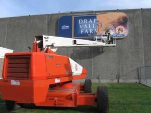 Workers install the new Northwest Gourmet Foods sign over the old Draper Farms sign on Seventh Street.