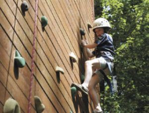 Ashley Pritchard climbs up the rock wall at the summer camp recently at the Camp Cedar River at the Renton Lions Youth Camp.