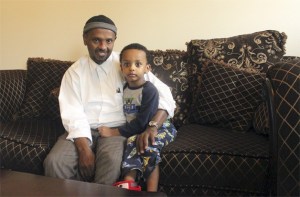 Yesihak Hassen and his son Jawhar sit in the living room of their new townhouse. The family is able to own the home through the efforts of Habitat for Humanity of East King County.
