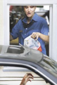 Nadia Encinas works one of two drive throughs at the newly re-opened McDonald’s on Rainier Avenue Wednesday. The restaurant burned down in December 2007.