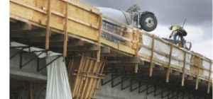 A construction worker tends to mixer trucks as they pour concrete on a new Interstate 405 bridge that will take freeway traffic over Oakesdale Avenue Southwest in Renton.