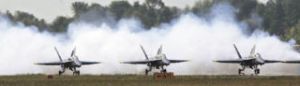 Three of four Blue Angels headed out for practice Thursday morning begin their takeoff roll at Boeing Field in front of smoke released for dramatic effect.