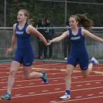 Natalie Surber (left) grabs the baton from McKaye Noel during the girl&rsquo;s 4x100 meter relay.