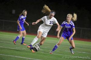 Bellevue Wolverines forward Kiley Suter, left, tries to manuever around Liberty sophomore defender Taylor Elfstrom in a contest on Sept. 29 at Bellevue Memorial Stadium. The Patriots defeated the Wolverines 3-2. Photo courtesy of Don Borin/Stop Action Photography