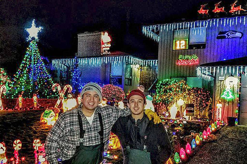 Danny Quintero, left, and his cousin Ray Monsegur, right, pose in front of Quinteros mother-in-laws house, which he decorated. (Courtesy photo)                                Danny QuinteroDanny QuinteroDanny QuinteroDanny Quintero