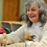 Judith Young chats with other carvers as she finishes up her figurine. (Leah Abraham | Renton Reporter)