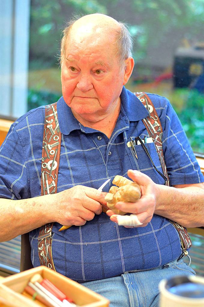 Sam Jeffries chisels away at woodcarving class. (Leah Abraham | Renton Reporter)