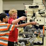 Joe Bergin, right, shows Sam Bhatt, right, how to run a mill during one of their after-school sessions. (Leah Abraham | Renton Reporter)