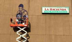 Courtesy photo                                Artist Will Schlough works on a mural of hometown hero Boone Boom Boom Kirkman. The mural will be celebrated Wednesday, Nov. 21 from 5 to 7 p.m. along the wall of La Hacienda Santa Fe on South 3rd Street.
