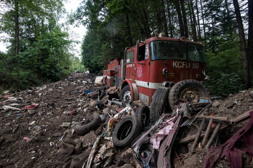 An old Skykomish Fire Engine sits amongst rubble. The pathway it sits on is riddled with tires and broken debris from other vehicles, whereas other areas are more clear of broken scrap. Photo by Caean Couto                                <em>Photo originally published <a href="www.rentonreporter.com/news/the-last-days-of-iron-mountain/" target="_blank">here</a></em>