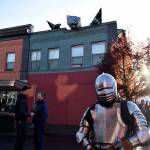 Mike Bergstrom in an impressive suit of armor stands valiantly amidst the newest addition to the downtown  a dragon. Photo by Haley Ausbun.