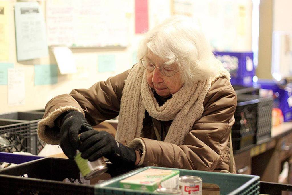 2016 volunteer Carol Abrahamson helps sort food at the Salvation Army Renton Rotary Food bank. From the Renton Reporter archives.