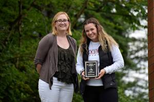 The first ever Female Athlete of the Year for the Renton Reporter, Lia Evans (right) is awarded a plague from the Renton Reporters editor Danielle Chastaine (left).                                Photo by Haley Ausbun