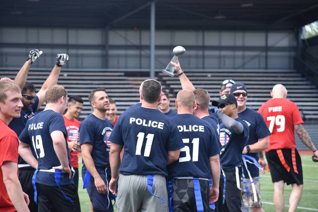 Photo by Haley Ausbun. Renton police celebrate their victory, and another year holding onto the trophy, at the 2019 First Responder Bowl on Saturday, June 8 at Renton Memorial Stadium.