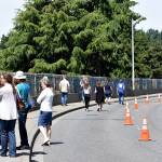 Photo by Haley Ausbun. Attendees of the Sunset fence dedication on June 9, walk along the 800 feet of art.