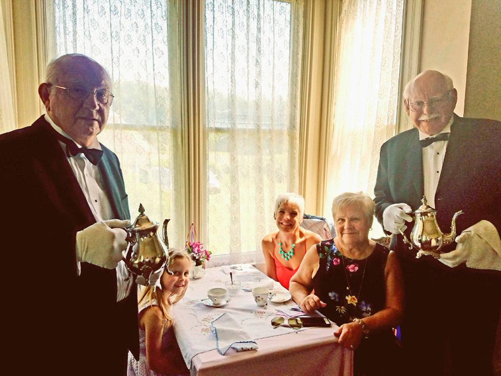 Nelly Mansion recently hosted a high tea event  Arnie Galli, Jr., left and Larry Galli serve Larrys wife, daughter and granddaughter, Molly. Arnie and Larry are the grandchildren of Ernst and Hannah Galli, who lived at Neely Mansion from 1908 to 1914. Photo by Karen Meador.