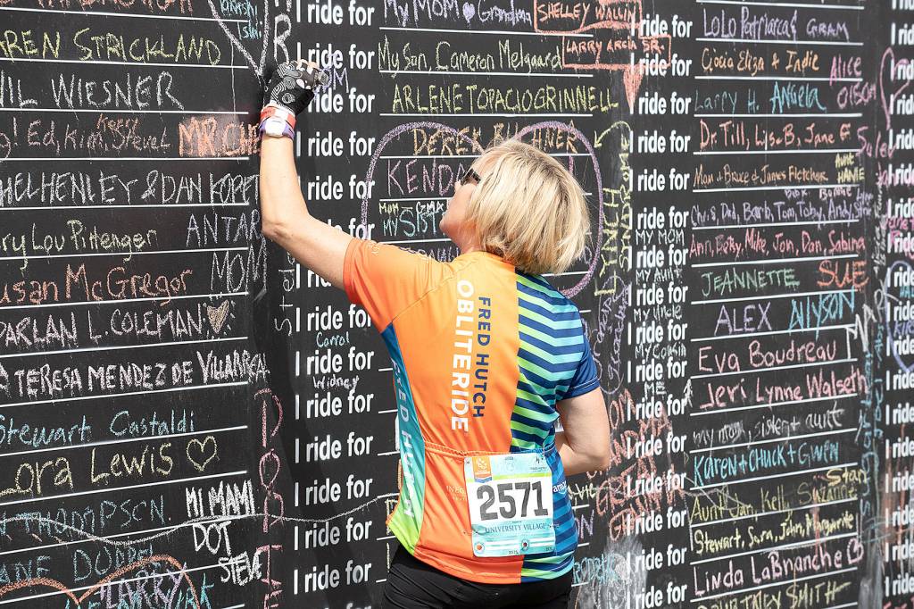 A Obliteride event participant writes the name of someone they love who was affected by cancer, which is why those choose to raise funds for Fred Hutchs cancer research. Photo courtesy of Fred Hutch Obliteride.