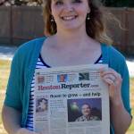 Photo by Haley Ausbun. Pastor Amy Lubienski, standing with a copy of a 2008 Renton Reporter story on her father, who was Pastor of Celebration Foursquare Church until his death in 2017.