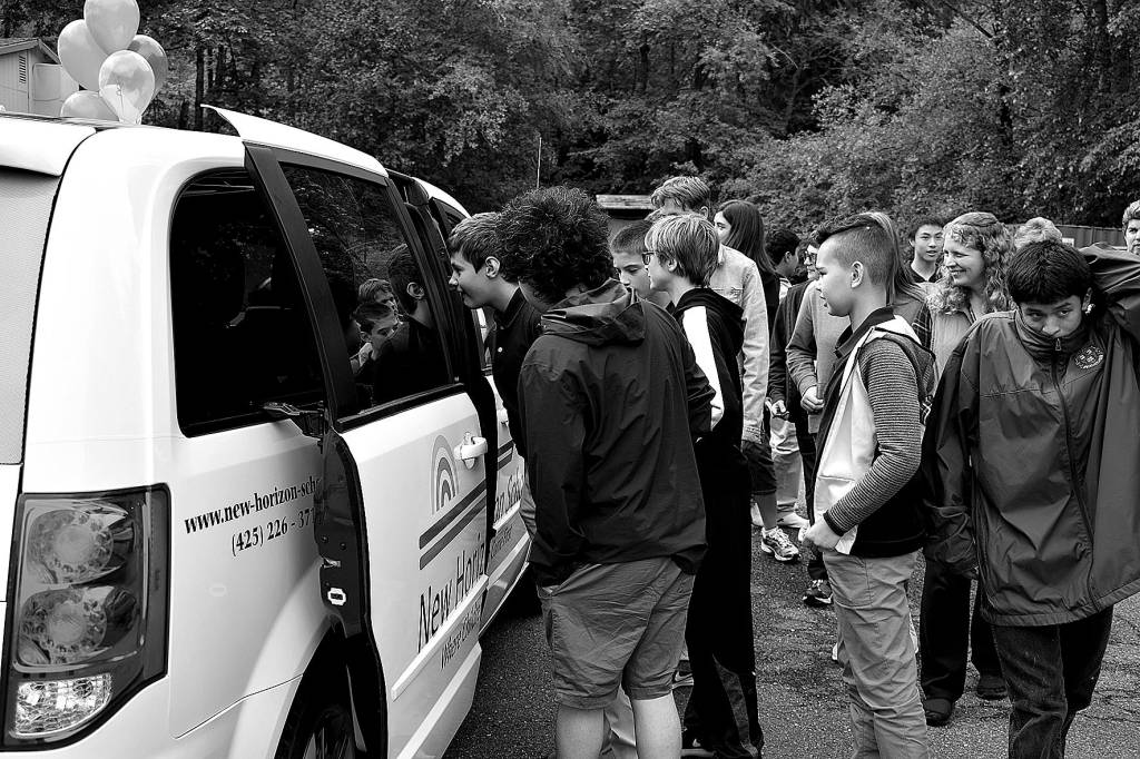 Photo by Haley Ausbun. At the Sept. 10 ribbon cutting, New Horizon School students get to check out their new van, gifted by King County Councilmember Reagan Dunn through the retired van program.