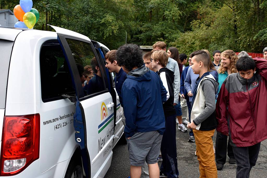 Photo by Haley Ausbun. At the Sept. 10 ribbon cutting, New Horizon School students get to check out their new van, gifted by King County Councilmember Reagan Dunn through the retired van program.