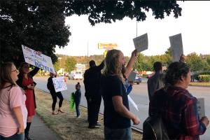 Photo by Haley Ausbun. Tiffany Park Elementary School teachers and parents hold up signs before the Sept. 11 Renton School Board meeting, over the loss of a fourth grade classroom that reorganized the fourth and fifth graders at the school.