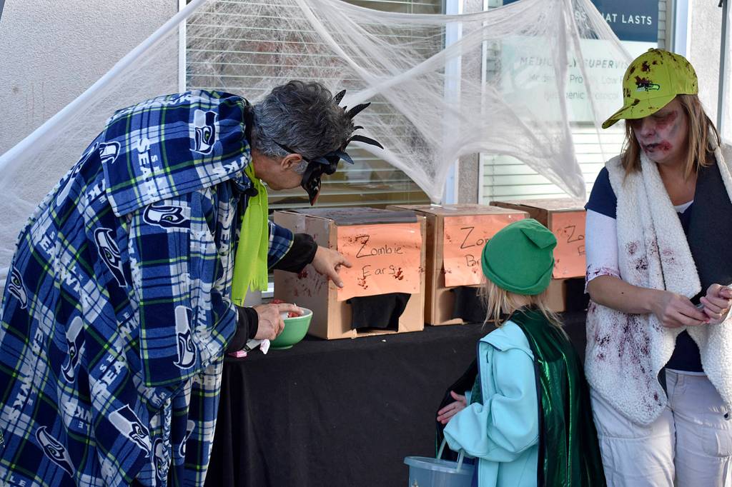 Photo by Haley Ausbun. Seahawks and zombies at one of the trick-or-treat stops at Olde Fashioned Halloween Party.