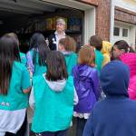 Photo by Haley Ausbun. Girl Scouts from troops 46754, 41126 and 41170 put together 400 sandwhich lunches on Saturday, Nov. 9 as part of Vision House kids serve event. The lunches then went to people experiencing homelessness in Seattle via Union Gospel Mission Search and Rescue. Here Vision Houses Venetia Vango offers girl scouts a tour of their residents store, where they give families living in Vision House apartments a free shopping experience twice a month.
