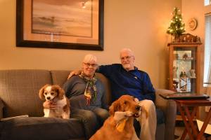 Photo by Haley Ausbun. Cindy Kraayeveld and her husband, Dave Kraayeveld, with their two dogs. Dave survived cardiac arrest thanks to first responders and a brave post office manager.