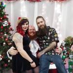 Photo courtesy of Handsome Devil Ink. Owners Maggie and Ryan Hammond with Bad Santa (center) at their annual Bad Santa Food Drive.