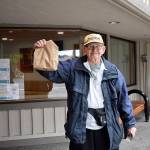 Photo by Haley Ausbun. Pictured: Bob, a Renton resident, picks up his drive thru lunch from the Renton Senior Activity Center, March 10. With the center closed through March 31 due to the coronavirus outbreak, staff are finding a clever way to get the critical lunch program out to seniors. For many seniors, staff say, its the only meal they have for the day. The drop-in lunch program now has sack lunches instead of a hot lunch. They will be available for drive through pick-up only, Monday through Friday from 11:30 a.m. to 12:30 p.m.
