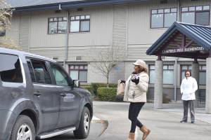 Renton School District employees hand out bagged lunches to families while schools remain shut down during the COVID-19 pandemic on Tuesday, March 17, 2020. Pictured: Campbell Hill Elementary School cook Annette Livingston. Photo by Haley Ausbun.
