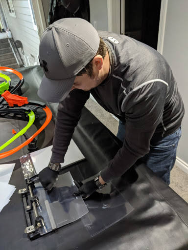 Ryan Schwalb punches holes in a transparent film to attach the face shield to a mask frame, creating personal protection equipment for frontline healthcare workers. Photo courtesy of Ryan Schwalb