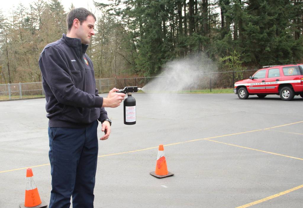 Firefighter James Hampson demonstrates the atomizing sprayer used to disinfect an officers weapons, body armor or other equipment. Olivia Sullivan/staff photo