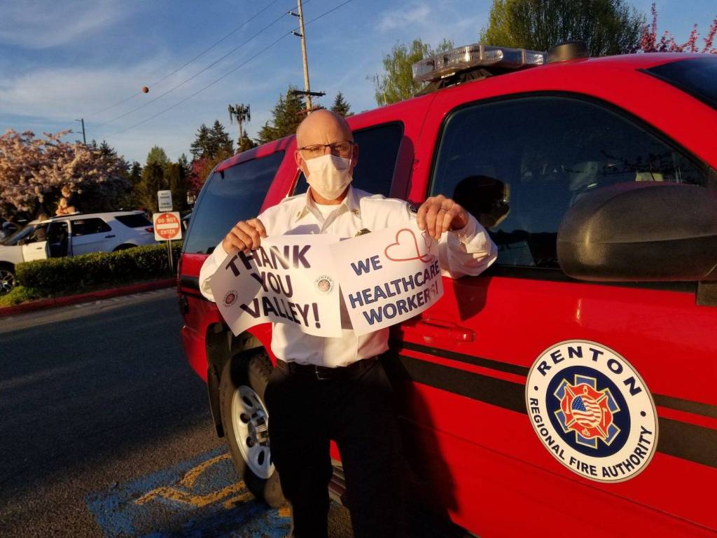 Fire Chief Rick Marshall holds signs of support during Thursdays Thank You parade. Photo courtesy of RRFA