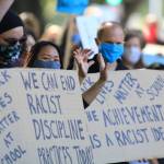 Lindbergh High School teachers hold signs calling for the end of racist discipline practices and the achievement gap. Photo by David Nelson.