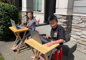 Two Renton School District students doing in-home learning, outside last spring. Courtesy photo/ Renton Schools Facebook page.