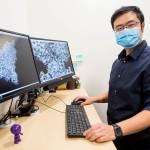 Dong Si, a University of Washington Bothell computational science professor, with two images of COVID-19 and a human cell created in tandem with his students. (Olivia Vanni / The Herald)