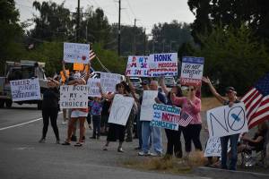 People hold up signs in protest of Gov. Jay Inslees latest proclamations during a Rally for Medical Freedom on Aug. 25 in Buckley. Photo by Alex Bruell/Sound Publishing