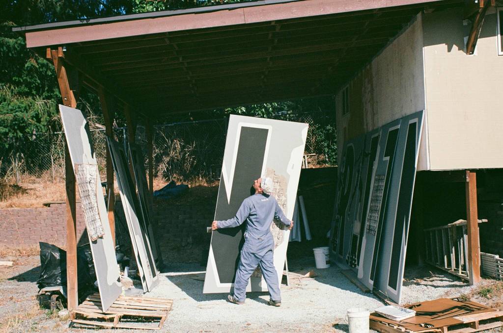 Alexander arranges the panels that will makeup the mural at Liberty Park (photo by Andrew Valentine)