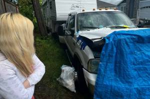 Jennifer examines Jareds broken down truck and immobilized trailer. (Cameron Sheppard/Sound Publishing)