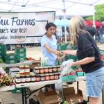 A customer buys strawberries from Sidhu Farms at the Renton Farmers Market. Photo: Bailey Jo Josie/Sound Publishing