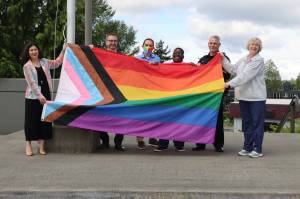 (From left to right) Renton City Councilmember Carmen Rivera, Mayor Armondo Pavone, Councilmember Ryan McIrvin, Councilmember Ed Prince, Police Chief Jon Schuldt and Councilmember Valerie OHalloran hold the Progress Pride flag outside of City Hall. Photo courtesy of the City of Renton.