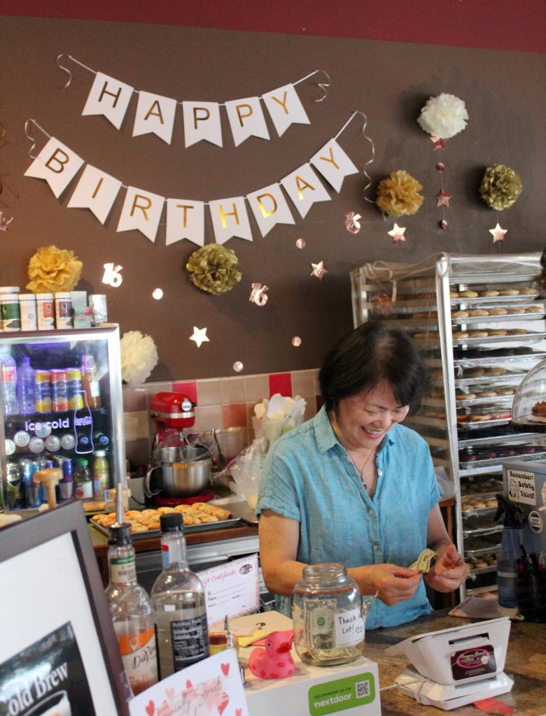 Heng Woon rings up one of the first customers of the day on Common Grounds 16th anniversary. Photo by Bailey Jo Josie/Sound Publishing.