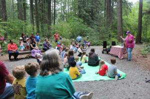 Children, parents, guardians and families gather in the Lake Wilderness Arboretum as Maple Valley librarian Sharon Chastain talks about the trees. Photo by Bailey Jo Josie/Sound Publishing.