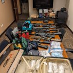 Law enforcement seized approximately 19 firearms, 3,372 grams of suspected methamphetamine, 1,322 grams of suspected fentanyl-laced pills, and over $210,000 in United States currency. (Courtesy of the Department of Justice)