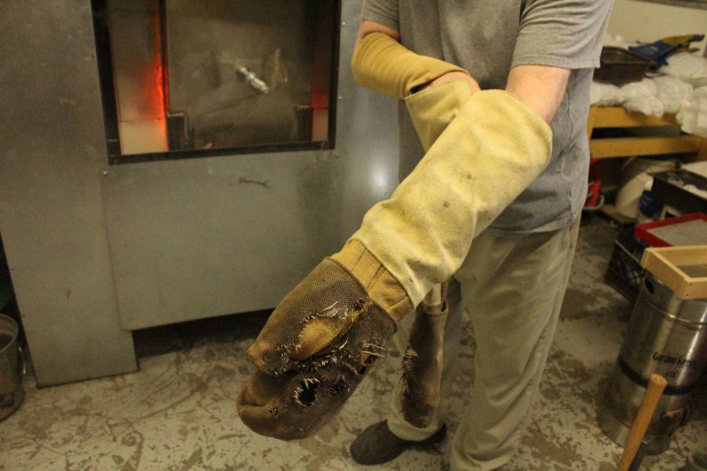 LEFT: Bob Mays puts on kevlar gloves to handle the hot glass hes been working on. 
ABOVE: Bob Mays has been making glass art for decades.
Photos by Bailey Jo Josie/Sound Publishing