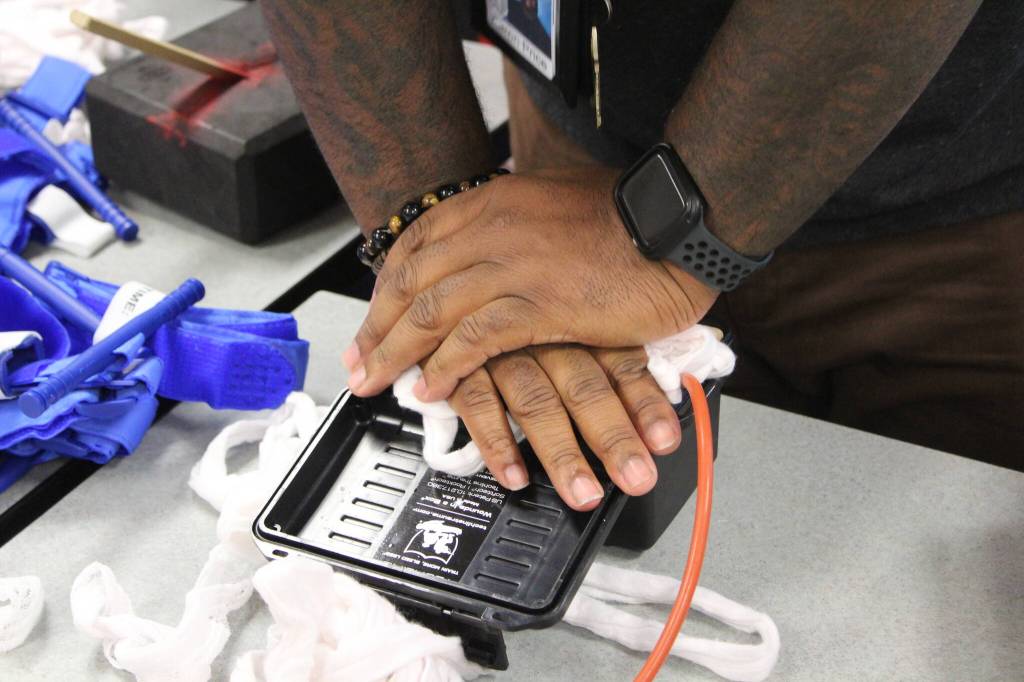 A Bryn Mawr staff member practices putting pressure on a wound model. Photo by Bailey Jo Josie/Sound Publishing.