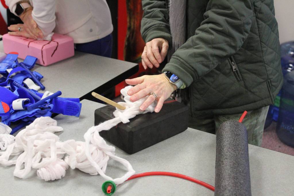 This staff member practices putting gauze and pressure around a projectile thats sticking out of the wound model. Photo by Bailey Jo Josie/Sound Publishing.