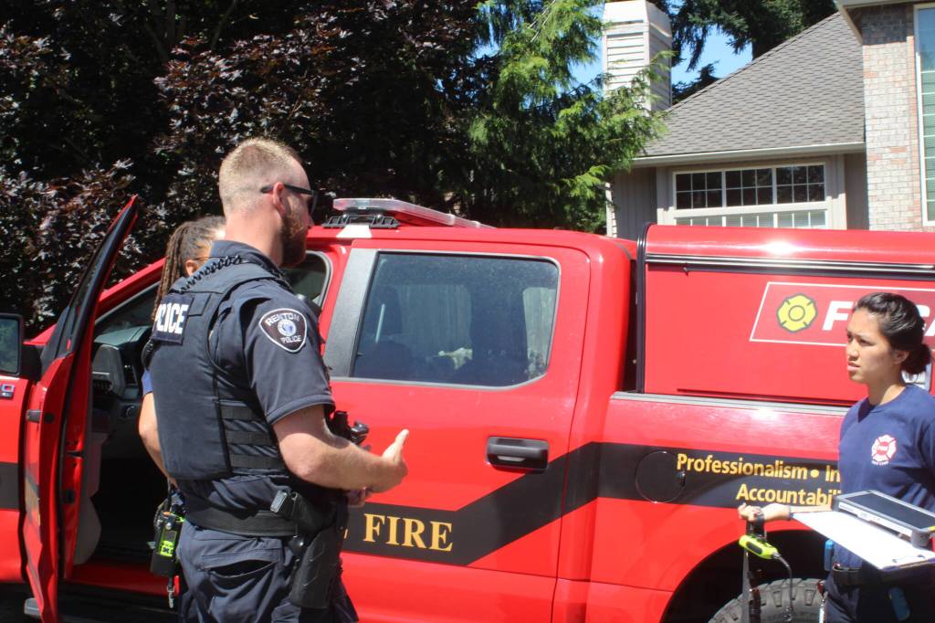 Officer Patrick Lantagne briefs an FD Cares unit regarding the condition of a man requesting assistance for homelessness. (Photos by Benjamin Leung/Renton Reporter)