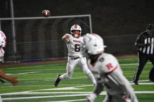 Demond Reed Jr. rolls to his left and throws to a receiver. Ben Ray / The Reporter